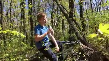一个骑自行车在<strong>树林</strong>里喝水的<strong>男孩</strong>